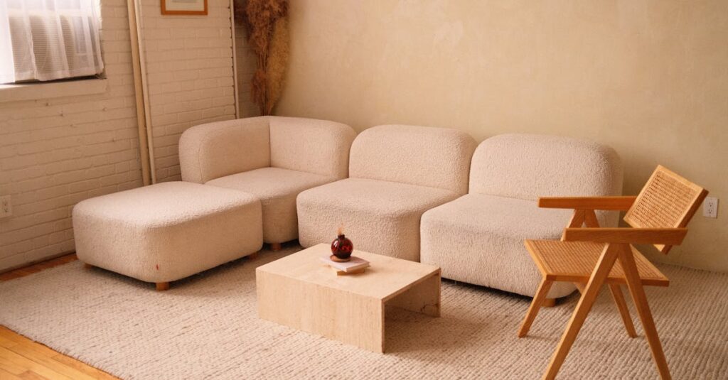 A cozy minimalist living room featuring a plush sofa and contemporary wooden chair.