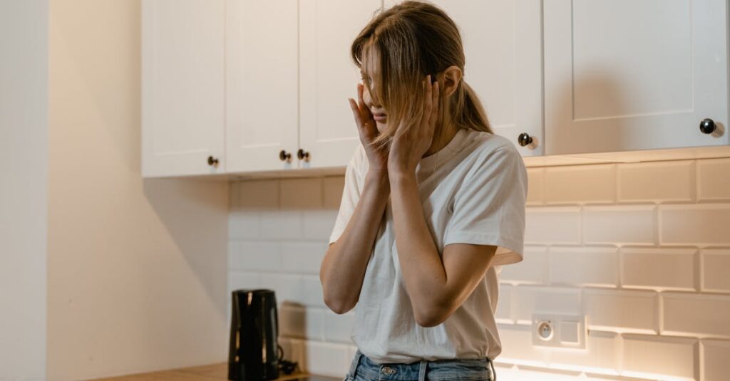 A woman in a modern kitchen looking distressed, emphasizing mental health awareness.
